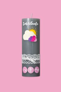 Graue Kerze mit weißer Aufschrift 'Zur heiligen Taufe', einer Wolke mit Sonne und Herzen sowie Spitzenband und drei Symbolen darunter