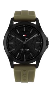 Tommy Hilfiger Armbanduhr mit schwarzem, strukturiertem Zifferblatt, dunklen Stundenmarkierungen und Zeigern, schwarzem Gehäuse und olivgrünem Silikonarmband in minimalistischem Dreizeiger-Design auf hellem Hintergrund