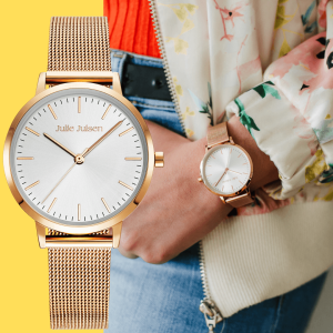 Julie Julsen Damenarmbanduhr mit roségoldenem Mesh-Armband und minimalistischem weißen Zifferblatt, abgebildet in einer Produktpräsentation neben einem Lifestyle-Foto der Uhr, getragen mit einer geblümten Jacke und einem Jeans-Outfit.