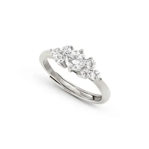 Eleganter silberfarbener Ring mit einem zentralen klaren Schmuckstein und mehreren kleineren funkelnden Schmucksteinen in klassischer Krappenfassung auf hellem Hintergrund