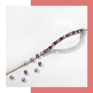 Zweifarbiges Armband mit funkelnden rosa Schmucksteinen und passenden Zierelementen auf hellem Hintergrund.