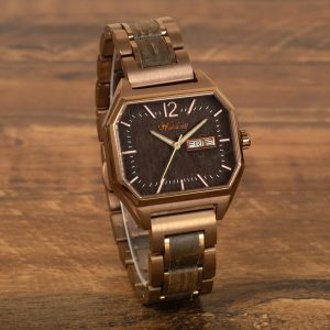 Waidzeit Armbanduhr mit bronzefarbenem achteckigem Gehäuse, dunklem Holzzifferblatt, Wochentags- und Datumsanzeige und passendem bronzefarbenen Metallarmband mit Holzeinlagen, präsentiert auf einer Holzoberfläche