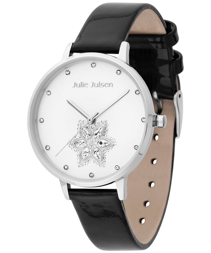 Freigestellte Produktaufnahme einer eleganten Damenarmbanduhr von Julie Julsen mit silberfarbenem Gehäuse, weißem Zifferblatt und schwarzem Lederarmband. Funkelnde Kristallindexe sowie ein dekoratives Blütenmotiv mit Kristallbesatz verleihen der Uhr einen femininen und stilvollen Charakter.