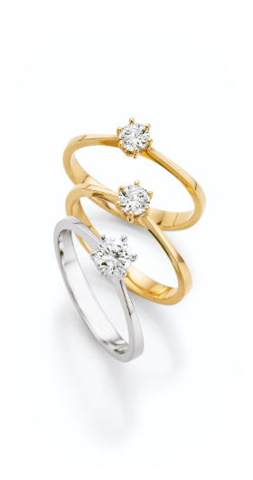 Zeitlose Solitärringe aus Gelb- und Weißgold mit brillantgeschliffenem Diamanten in eleganter Krappenfassung. Die filigrane Ringschiene lenkt den Blick auf den funkelnden Mittelstein und unterstreicht dessen natürliche Brillanz. Ein stilvoller Klassiker für Verlobung, Hochzeit oder besondere Anlässe.