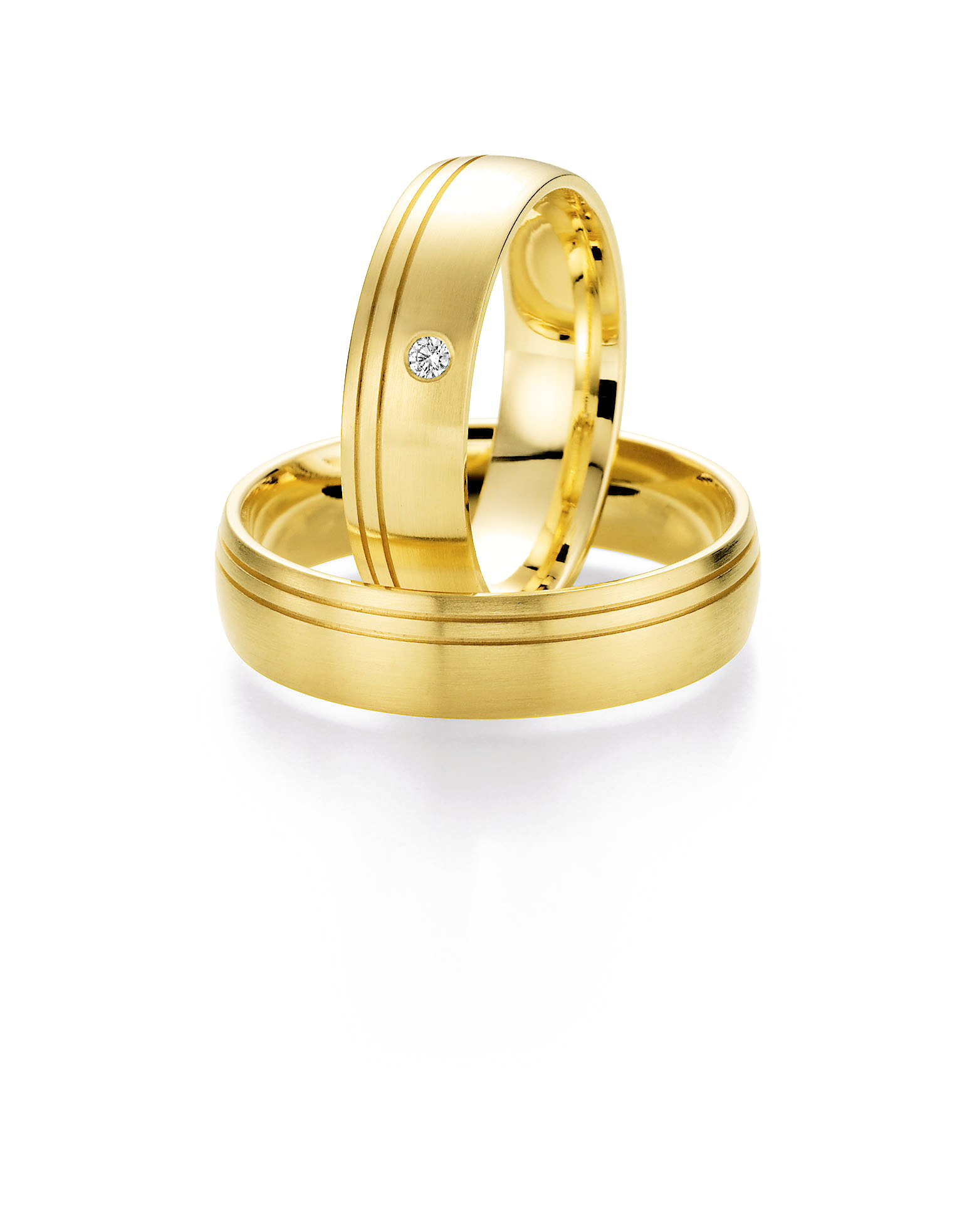 Zeitlose Trauringe aus Gelbgold mit edler mattierter Oberfläche und feinen umlaufenden Zierlinien. Der Damenring wird durch einen dezent eingefassten Brillanten veredelt und setzt einen eleganten Akzent. Ein klassisches Ringpaar, das Beständigkeit, Verbundenheit und stilvolle Schlichtheit vereint.