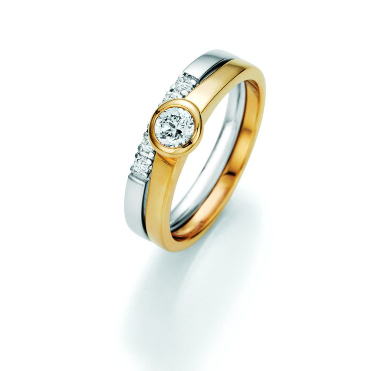 Eleganter Ring aus Gelb- und Weißgold mit zentral gefasstem Brillant und seitlichem Diamantbesatz