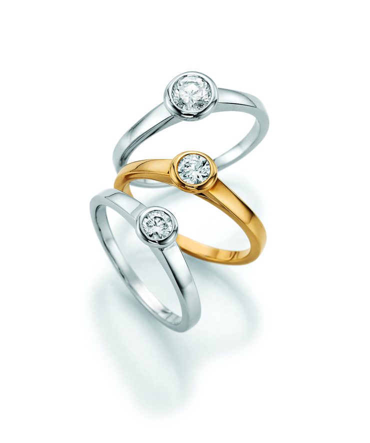 Zeitlose Solitärringe aus Weißgold und Gelbgold mit brillantgeschliffenem Diamanten in eleganter Zargenfassung. Das schlichte, moderne Design betont die Schönheit des Steins und macht die Ringe zu stilvollen Begleitern für Verlobung, Jubiläum oder besondere Momente.